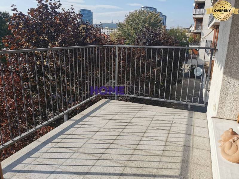 Balkon 2-pokojového bytu na Drieňové ulici v Bratislavě - Ružinově se zelení v pozadí.