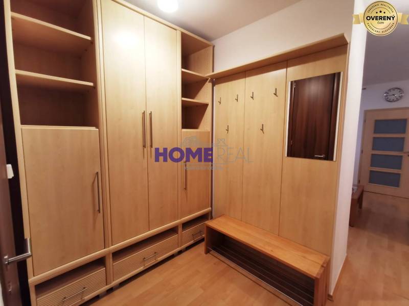 Vstupní hala ve 2-pokojovém bytě s nábytkem z dřevěného dekoru a zrcadlem.