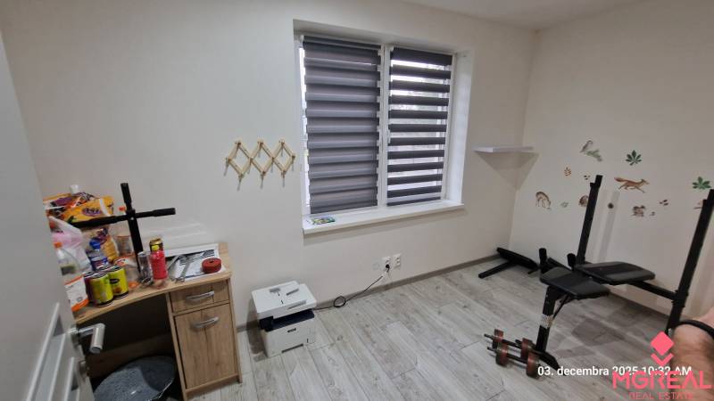 Pokoj v rodinném domě s podlahou s dřevěným dekorem, posilovací lavicí a stolkem.