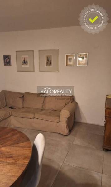 Obývací pokoj v 3pokojovém bytě s pohovkou, podlaha s dřevěným dekorem a dekoračními obrazy.