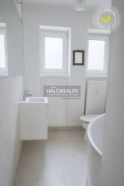 Koupelna ve 3-pokojovém bytě s bílým umyvadlem, vanou a radiátorem.