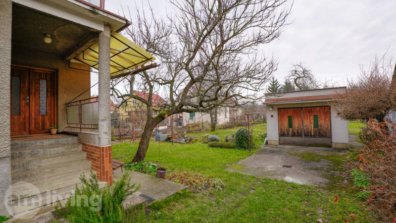 Před rodinným domem na Nerudově ulici v Dubnici nad Váhom je zahrada se stromem.