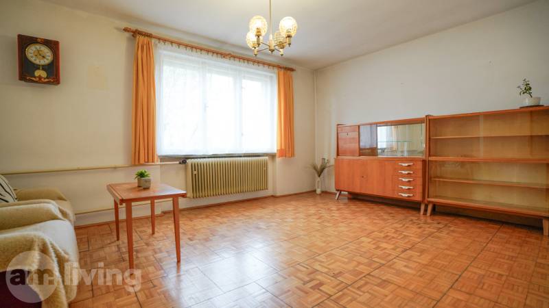 Obývací pokoj v rodinném domě s nábytkem a podlahou s dřevěným dekorem.