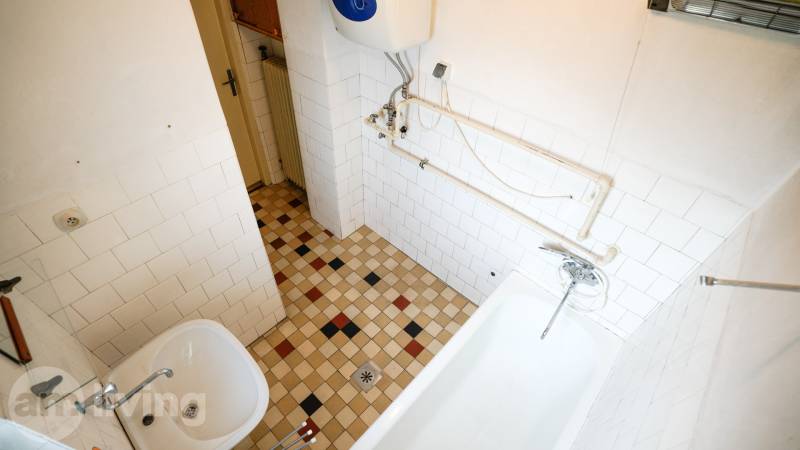 Koupelna s dlažbou a vanou v rodinném domě.