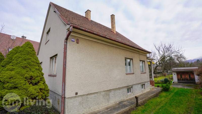 Rodinný dům na Nerudově ulici v Dubnici nad Váhom, obklopený zelení a stromy.