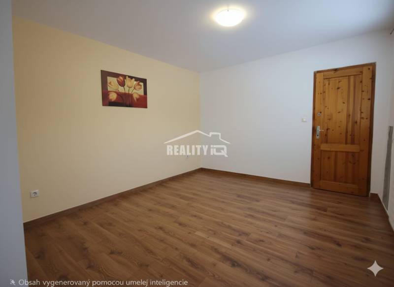 Pokoj s podlahou s dřevěným dekorem, obrazem na stěně a dřevěnými dveřmi.