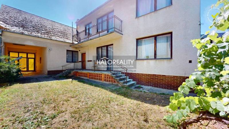 Rodinný dům v Malackách s balkonem, schody a zahradou, k němu náleží přístřešek.