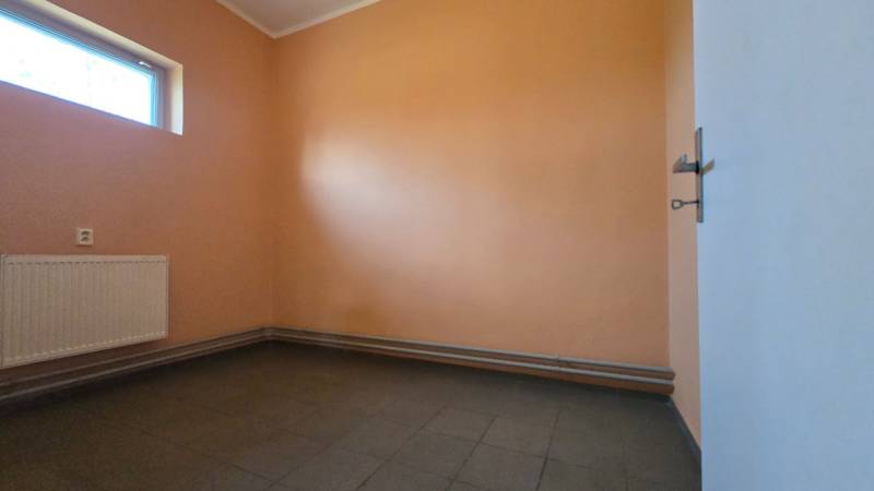 Bezpečnostní místnost s oknem, radiátorem a dlažbou. Sklady a haly.