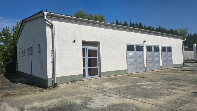 Bílá budova s kovovými dveřmi ve skladové a halové zóně města Šaľa.