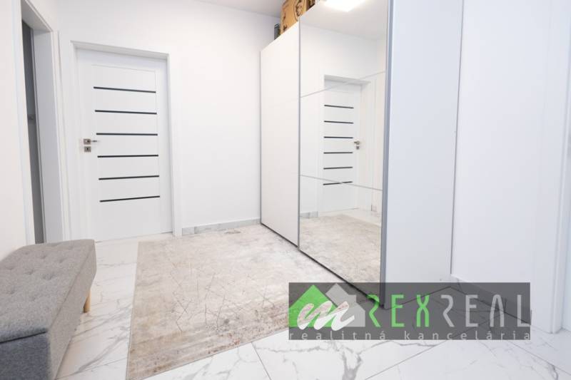 Chodba s kobercem, zrcadlovou skříní a dveřmi v 3-pokojovém bytě.