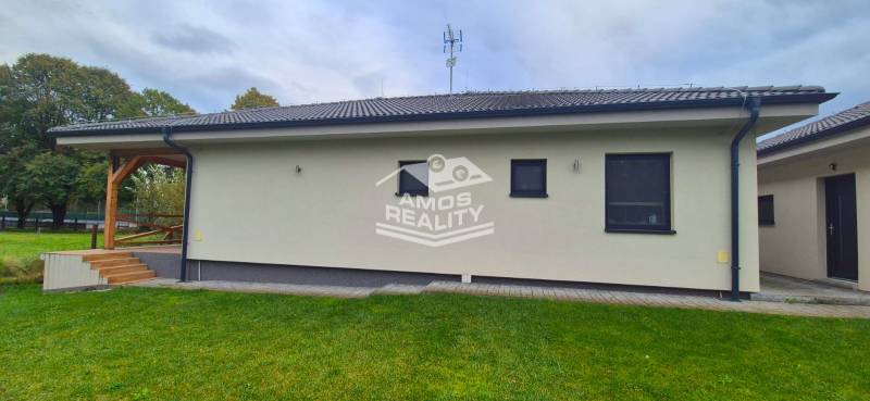 Rodinný dům ve Studience s terasou, zeleným trávníkem a moderní fasádou.