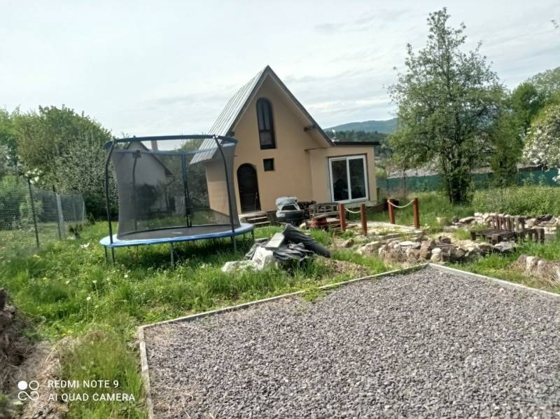 Chata v Hliníku nad Hronom s trampolínou a kamenitou cestou v zahradě.