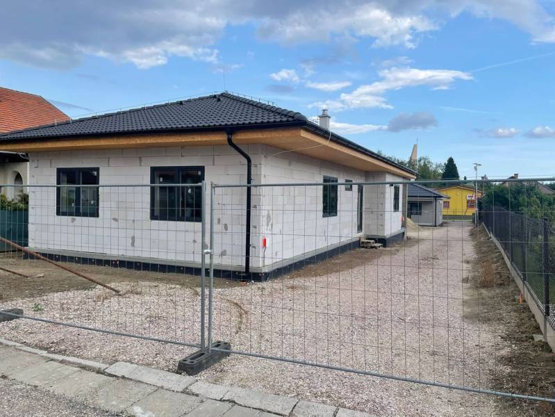 V Radavě probíhá výstavba rodinného domu se šikmou střechou a bílou fasádou.