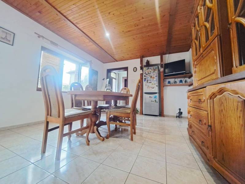 Jídelna v rodinném domě s dřevěným stropem a dlažbou.