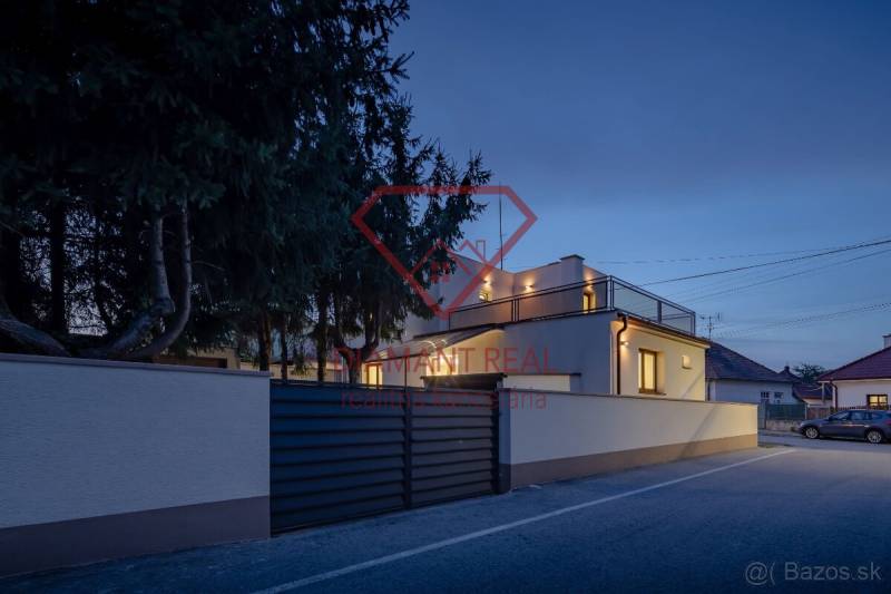 Rodinný dům na Trnovecké ulici v Trnovci nad Váhem během večerního osvětlení.