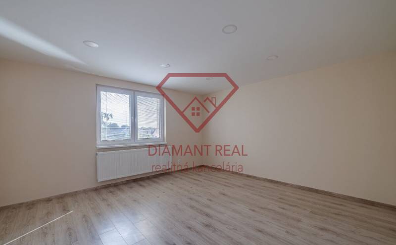 Pokoj s podlahou s dřevěným dekorem a velkým oknem v rodinném domě.