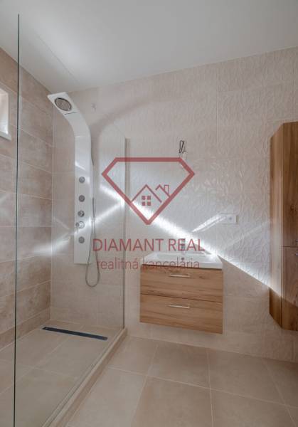 Koupelna se sprchou a nábytkem s dřevěným dekorem v rodinném domě.