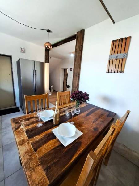 Jídelní stůl s doplňky a lednička v kuchyni rodinného domu.