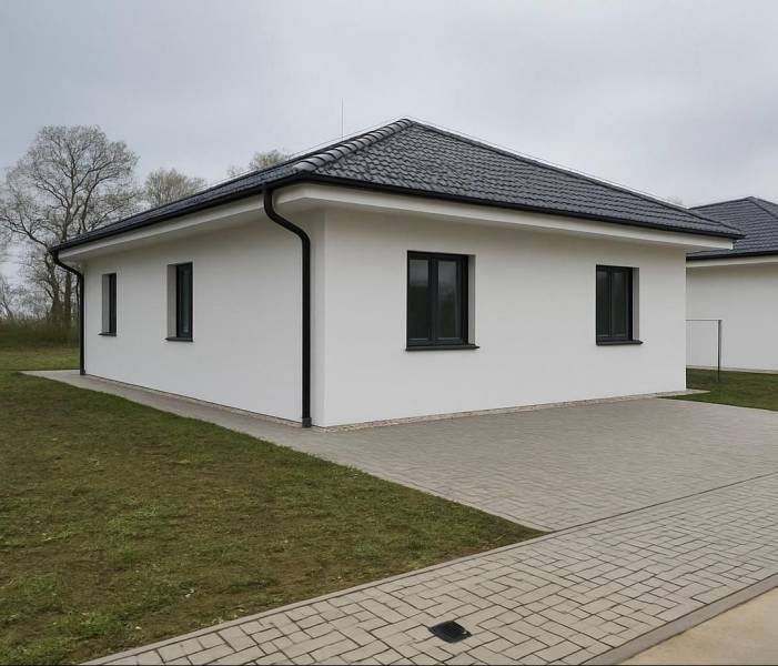 Rodinný dům v Cíferi se šikmou střechou a dlážděným chodníkem.