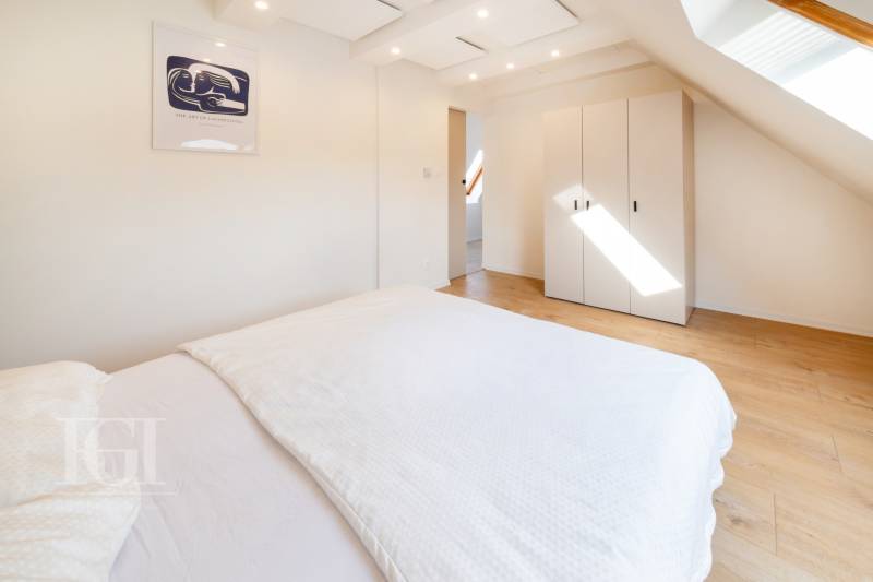 Ložnice s podlahou s dřevěným dekorem a skříní v 2-pokojovém bytě.