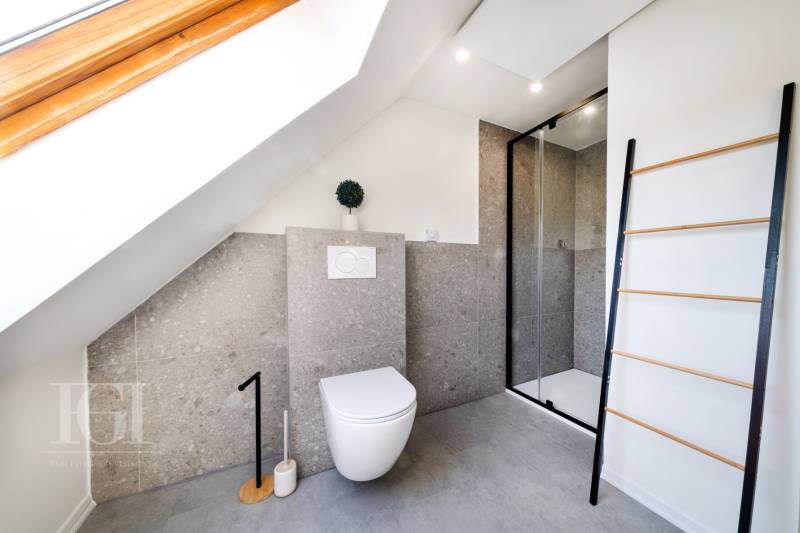 Koupelna s toaletou a sprchovým koutem v 2pokojovém bytě, pod šikmou střechou.