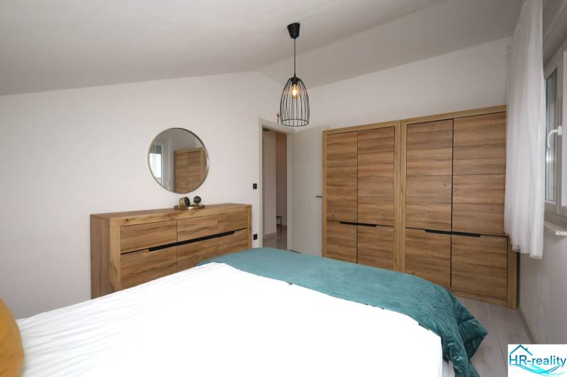 Pro Rekreační apartmán jsou typické skříně a komoda s dřevěným dekorem a zrcadlem.