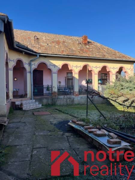 Rodinný dům v Tomášovcích s terasou a zdobenou fasádou.