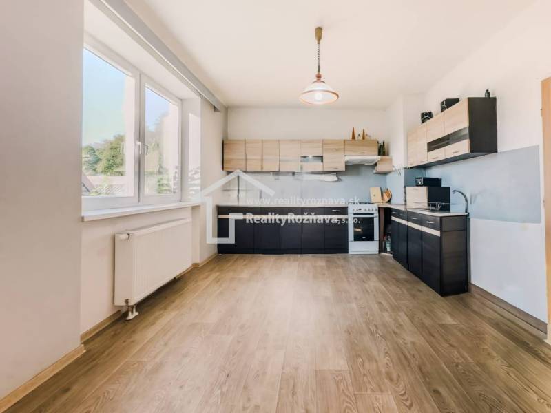 Kuchyně v rodinném domě s podlahou s dřevěným dekorem a velkým oknem.