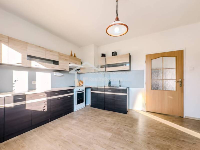 Kuchyně v rodinném domě s podlahou s dřevěným dekorem a moderními linkami.