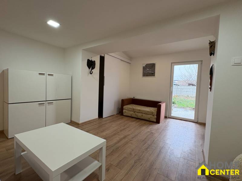 Obývací pokoj v 1-pokojovém bytě s nábytkem a podlahou s dřevěným dekorem.