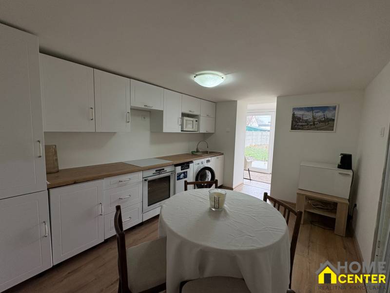 Kuchyně v 1-pokojovém bytě s podlahou s dřevěným dekorem a jídelním stolem.