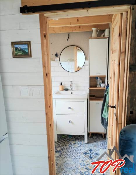 Koupelna v rodinném domě s kulatým zrcadlem a vzorovanou dlažbou.