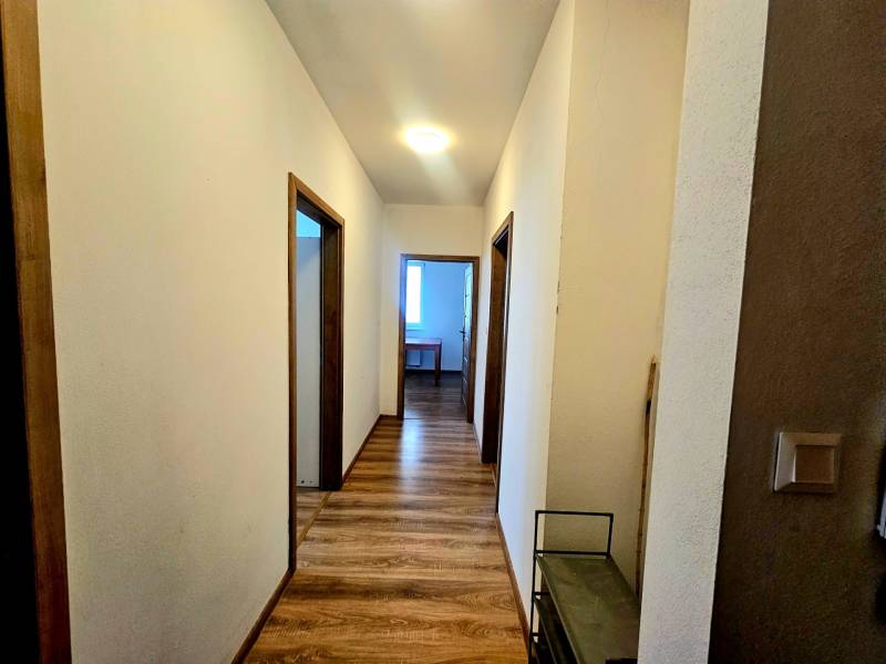 Chodba s podlahou s dřevěným dekorem v 2-pokojovém bytě.