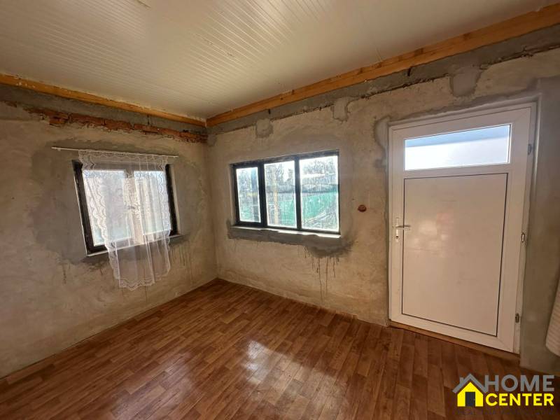 Interiér s podlahou s dřevěným dekorem a bílými dveřmi v části Zahrady.