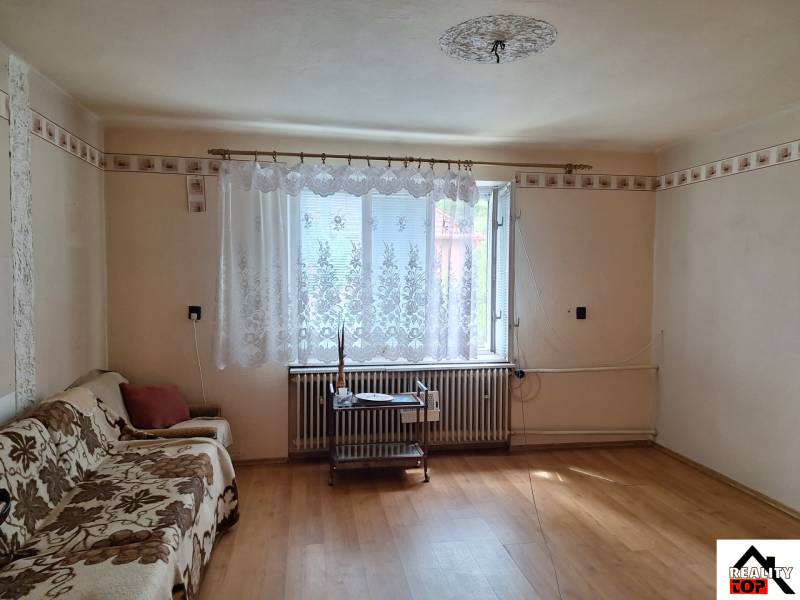 Obývací pokoj v rodinném domě s podlahou s dřevěným dekorem a pohovkou.