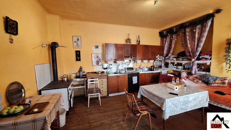 Kuchyně s dřevěným dekorem, rustikálními skříňkami a dekoracemi v rodinném domě.