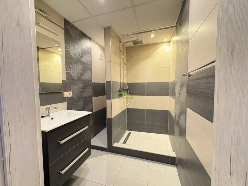 Koupelna se sprchovým koutem a umyvadlem v 3-pokojovém bytě.