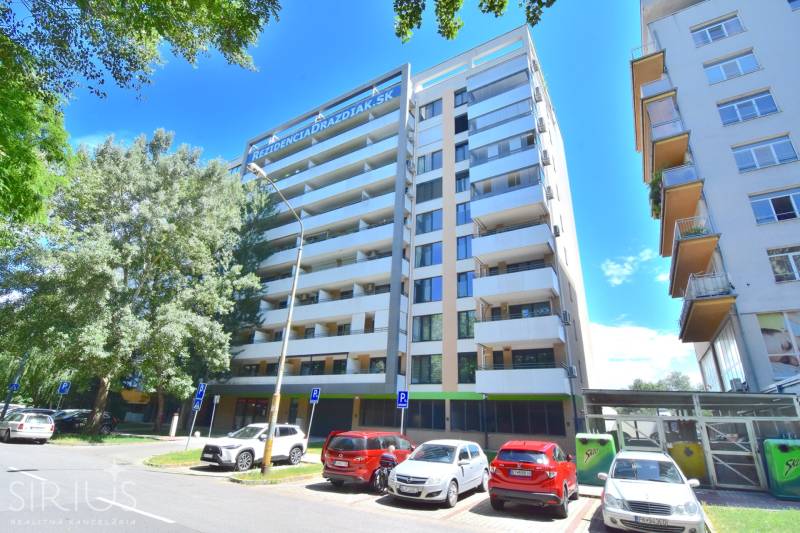 Bytový dům u Antolské ulice, Bratislava - Petržalka, s parkovištěm a stromy v okolí.