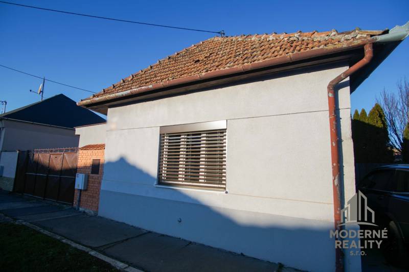 Rodinný dům na ulici Pod kopcem v Nových Zámcích s roletami a šikmou střechou.