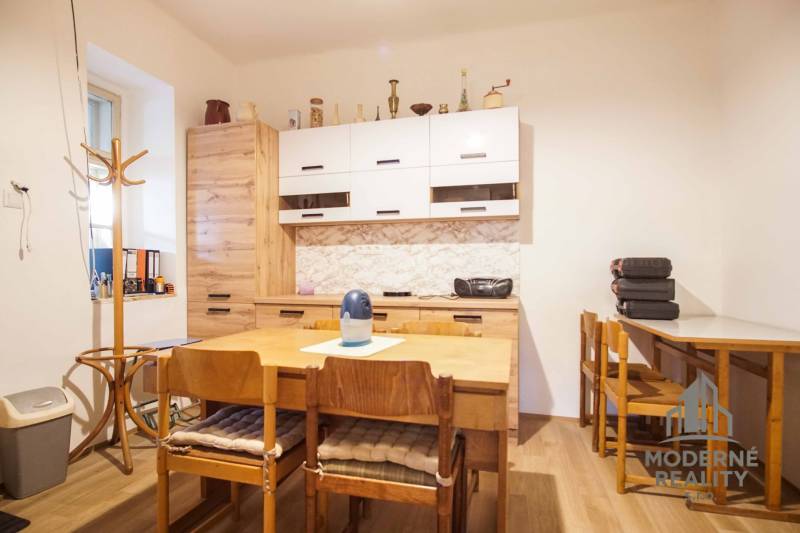 Jídelna s dřevěným nábytkem, podlahou s dřevěným dekorem v rodinném domě.