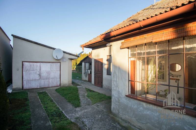 Rodinný dům na ulici Pod kopcem v Nových Zámcích s garáží a satelitní anténou.