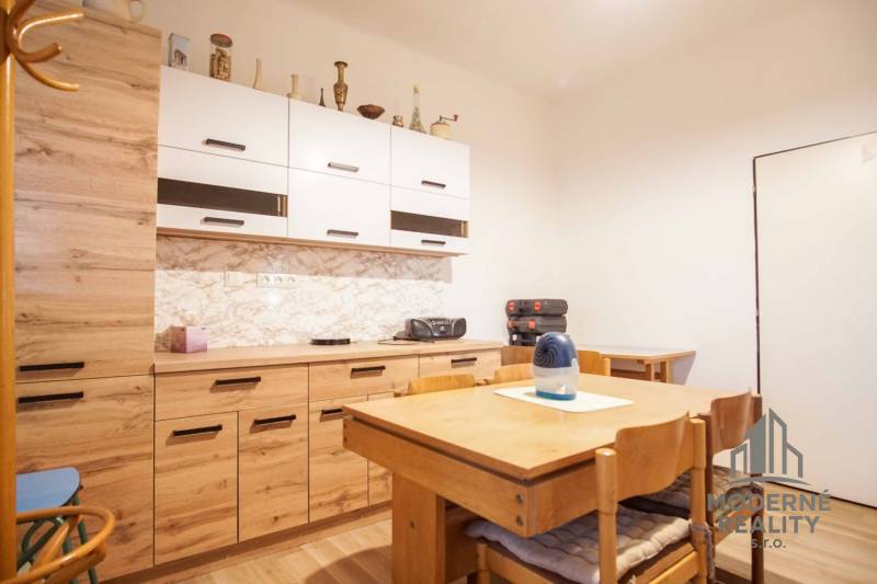 Kuchyně v rodinném domě s dřevěným nábytkem a podlahou s dřevěným dekorem.