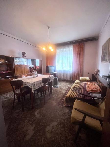 Interiér rodinného domu s jídelním stolem, pohovkou a televizí.