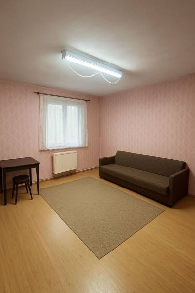 Pokoj v rodinném domě s hnědou pohovkou, stolem a podlahou s dřevěným dekorem.