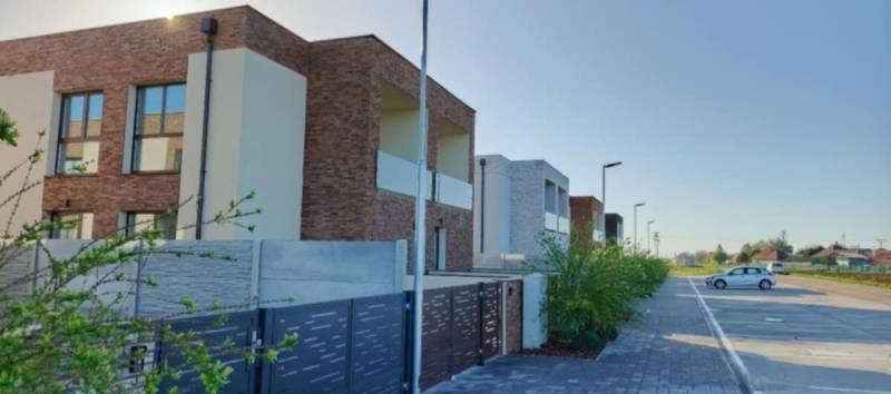 Moderní bytové domy v Diakovcích se soukromým parkovištěm a upravenou zelení.