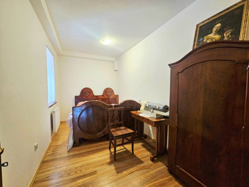 Ložnice s starožitným nábytkem, postelí a skříní s podlahou s dřevěným dekorem.