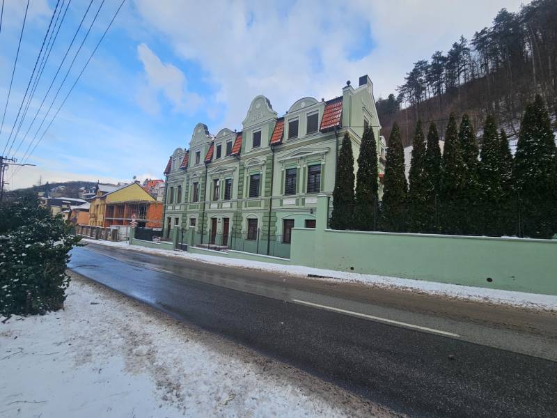 Zelená budova se třemi obloukovými střechami na Šrobárově ulici v Trenčianských Teplicích.