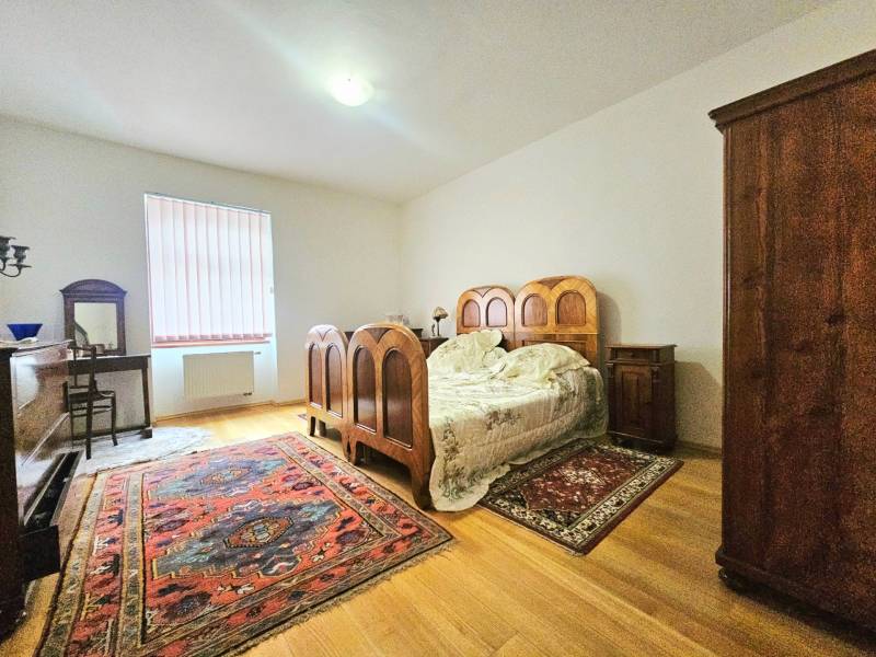 Ložnice v 3-pokojovém bytě s dřevěným dekorem a vintage nábytkem.