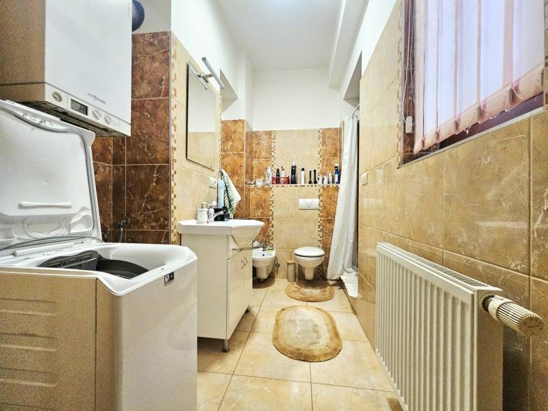 3pokojový byt s koupelnou, pračkou, vanou a oknem, dekorativní obklady na stěnách.