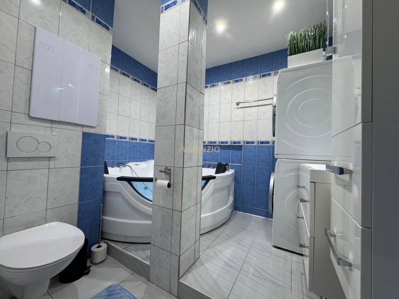 Koupelna s toaletou a vířivkou ve 3-pokojovém bytě, dominují modré kachličky.